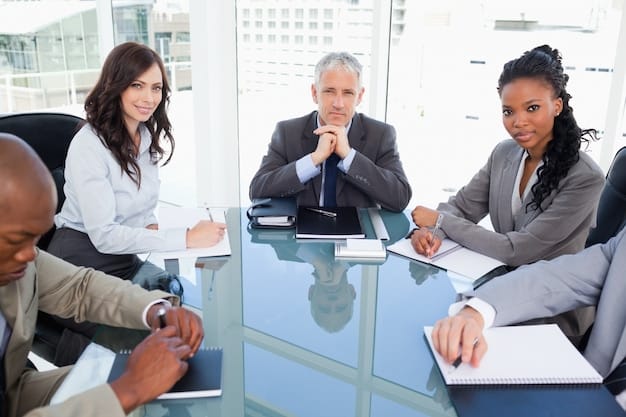 A diverse group of business executives and board members gathered around a table, intensely discussing cybersecurity on a large digital screen, symbolizing high-level awareness and strategic decision-making in corporate security.