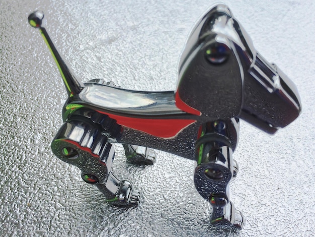 A close-up, dynamic shot of a small, sleek autonomous delivery robot gliding smoothly on a clean sidewalk in a modern urban setting. The robot has a secure compartment for packages and uses advanced sensors to navigate around pedestrians and obstacles.