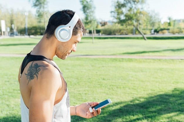 A person jogging outdoors, wearing wireless earbuds, with a smartphone armband, implying active use and the need for long battery life during exercise, set against a blurred background of a park path.