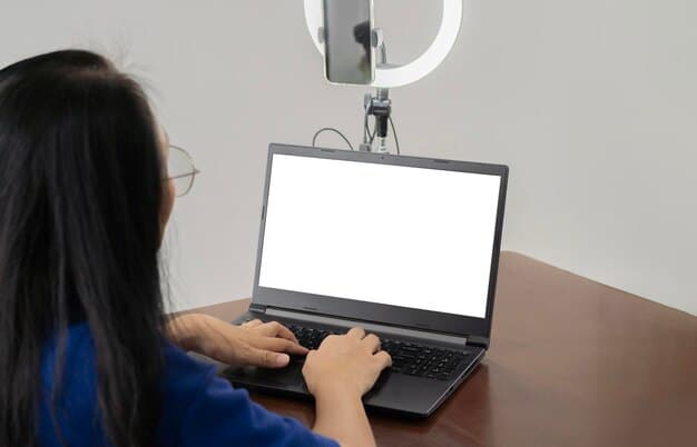 A person's hand adjusting a webcam's mount on a laptop screen, demonstrating precise positioning and setup for a video call.